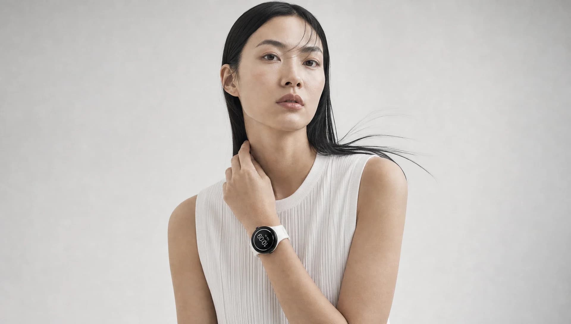 A woman in a white top wearing the smartwatch